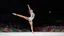 Placeholder: Please provide a detailed Photo of a female gymnast performing her routine on the floor exercise at the Olympic Games. Include specific elements of her performance, such as her choreography, the difficulty of her moves, her artistry, and how she engages the audience. Additionally, describe the atmosphere of the event, the reactions of the crowd, and any notable aspects of her presentation. The output should be structured in a way that captures the excitement and technical skill of the performanc