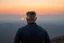 Placeholder: a brawny man with grey hair views sunset from a cliff