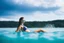 Placeholder: close up shot of very beautiful model girl swimming in water wearing swim suit ,country side ,nice cloudy sky,country houses