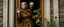 Placeholder: close up portrait painted by Rembrandt, Maya is standing in the doorway with one hand still on the handle. She looks surprised, but not frightened. The zombie is wearing an old brown coat with patches on the elbows. His shoes don't match. What's surprising is that he's carrying a bunch of wildflowers. One of them has slipped from his hand and landed upside down on the porch. The rain is falling everywhere except on the flowers. That's a little strange. The story doesn't mention it.