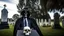 Placeholder: photo of a hoodless grim reaper wearing a suit, highlighting shiny areas of the skull, sitting outside a cemetery with a welcome sign, wearing suit, rim lighting, studio lighting, looking at the camera, dslr, ultra quality, sharp focus, tack sharp, dof, film grain, Fujifilm XT3, crystal clear, 8K UHD, clean, orange evening lighting