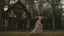 Placeholder: slim nymph dancing in a woodland clearing, with a gothic woodland house behind her.