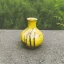 Placeholder: artistic photo of a tiny cracked ceramic vase repaired with gold, kintsugi, garden setting, beautiful landscape photography, beautiful, vines and leaves, delicate, cinematic, high detail, beautiful composition, delicate arrangement, aesthetic, soft lighting, award winning photography, tender