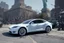 Placeholder: A Tesla 'Model 3' is parked, near the 'Statue of Liberty' in New York. CINEMATIC. WIDE ANGLE LENS. PHOTO REAL.