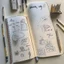 Placeholder: A bulletjournal with drawings and writing on a table with drawing tools