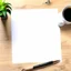 Placeholder: Art Studio Desk with a blank piece of papier, realistic art supplies, realistic drawing, top view, studio light, zoom out to see part of the desk. plant for decoration, art supplies on the desk, ultra real, coffee on the side