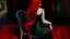 Placeholder: Avant-garde painting. We see a girl from behind, in a black dress, lazily, half-lying on a chair, her legs tightly crossed, one hand loosely draped over the back of the chair. Her long red hair falls down her back.