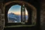 Placeholder: A castle window with a view of winter landscape where a dragon with green and yellow skin flies