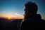 Placeholder: a brawny man with grey hair views sunset from a cliff