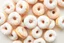 Placeholder: random floating evenly powdered mini cake donuts, with the donuts overlapping and the powdered sugar coating them evenly. The background should be white or a light neutral color.