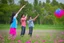 Placeholder: a father, a girl and a boy with a kite flying in the sky on the green field with flowers in sunshine