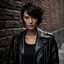 Placeholder: cute woman with dark short hair with light streaks, gray eyes, facial skin with very noticeable unevenness and pores, facial skin like a leather jacket, wearing a black jacket, standing by an old brick wall on the street during the day, abstract neorealism, cinematic, film light, hyper-detailed , hyper-realistic, masterpiece, atmospheric, high resolution, 8k, HDR, FUJIFILM, photo, bokeh