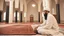 Placeholder: Religious leader, male, 30 years old, at the mosque wearing a turban, traditional Islamic cap, and using a prayer rug.