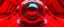 Placeholder: low view angle shot down from upper left front and showing the full vehicle, a RETROFUTURISTIC HOVERING CRAFT OF ALIEN ORIGIN, large close up a beautiful look up modern is decorated with red abstract, all red background, fisheye lense, vray, raytracing