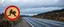Placeholder: roadside sign warning about dangerous artwork resembling a road in the road