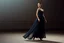Placeholder: Full-body fashion editorial photograph of an elegant and beautiful woman. She is wearing a sophisticated, delicate dark cyan lace evening gown with modest coverage and matching high heels. Captured in a high-end luxury ballet stage setting with soft, dramatic studio lighting that highlights the texture of the lace. Graceful posture, professional model pose, realistic skin textures, cinematic atmosphere, haute couture style in a luxury stage.