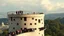 Placeholder: Cylindrical tower with lots of randomly placed windows, viewing platform on top, long queue of people waiting to go in, award-winning photograph, exquisite detail and realism