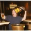 Placeholder: William Luby pouring a bucket full of beer on his own head at a pub