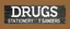 Placeholder: a hand painted sign on dark painted wood planks, first line says "DRUGS", second line (Smaller) says "STATIONERY T SANDERS", on a brown background