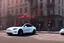 Placeholder: A Tesla 'Model S' is going at a high speed, near the building of the 'Friends' series in New York. (CINEMATIC, WIDE ANGLE LENS, PHOTO REAL)