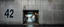 Placeholder: background of wall(wet textured concrete, gray, old, cracked, stained) from underground parking, hong kong style, a large number "42" painted on left(old faded paint), at middle is an opening into an area with asian shops, cyberpunk