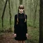 Placeholder: lily-rose Depp as Wednesday addams, braids, bangs, in tge woods