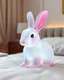 Placeholder: Generate image: A macro 3D render of a cute, lovely wooly rabit,made of Translucent glossy jelly material, soft gelatinous appearance, smooth rounded surface, realistic subsurface scattering, internal light diffusion, subtle volumetric translucency, wet polished highlights, slightly reflective surface, soft rubbery-plastic texture, vibrant neon color, physically based shader, studio lighting, high-end CGI render.on a conform in a luxury bedroom.