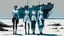 Placeholder: ((three)) determined cyberpunk women (wearing white khiton) standing in front of a boat wreck on a radioactive beach, three women, acrylic painting, minimal art, centered, wild sparse brushstrokes, amazing verticals, great parallels, low bleak colors of gray, blue and black, excellent negative space contrasts
