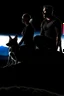 Placeholder: Black background on a mountaintop. A silhouette of a fit man and a silhouette of a fit woman sitting close to each other. A silhouette of a Belgian malinois somewhere close to them. There are three slouches in the picture, a man, a woman, and a dog.