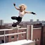 Placeholder: Sandra Dee in agent provocateur parkour athletes, jumping over a fence, jumping over a hedge, jumping onto a roof, aiding and abetting and jumping onto the roof of a building, and finally jumping from the roof of a building to the roof of a building far away, victory pose. Winter clothing.