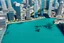 Placeholder: There is a city with a lot of tall buildings. Most of the tall buildings are submerged in ocean. Just a few portions of tall buildings are above the water.