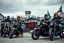 Placeholder: a very hard and tuff motorcycle young gang with Keltic hair , not old, posing with their Harley Davidsson bikes, some of them holding guns and shotguns, a logo sign with "FALKÖPING HD", "FEARLESS SINNERS" Skulls and bones, skeletons and fire, Swedish town Falköping in background, Swedish flags on bikes, Simon Stålenhag style
