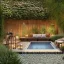 Placeholder: a gorgeous, stunning garden deck with rustic walls and floor, wicker furniture, string of illuminated globes, tranquil pool surrounded by smooth stones, lit candles, foliage, cozy, 8k resolution, high-quality, fine-detail, zen-like, digital art, detailed matte, volumetric lighting, illustration, 3D octane render, brian froud, howard lyon, selina french, annie stokes, lisa parker, greg rutowski