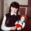 Placeholder: Wednesday addams with bangs and braids, with a chucky doll, old polaroid