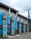 Placeholder: A gray factory with iron clocks designed in pacific Northwest totem poles painted by Cai Jia