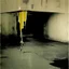 Placeholder: Minimal abstract oil paintings and graffiti in a desolate 1960s carpark concrete fragments and road markings. Broken pipes. In the style of Justin Mortimer and Francis Bacon. Muted yellows.