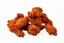 Placeholder: A cinematic shot of a full plate of Southern fried chicken wings. The wings are golden brown and crispy, with a few stacked on top of each other and the rest scattered across the plate. The background is a plain white surface. The lighting is warm and inviting.