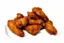 Placeholder: A cinematic shot of a full plate of Southern fried chicken wings. The wings are golden brown and crispy, with a few stacked on top of each other and the rest scattered across the plate. The background is a plain white surface. The lighting is warm and inviting.