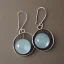 Placeholder: round earring, jewlery, silver, crescent moon, aquamarine eyes, bird wings