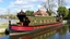 Placeholder: Historic traditional horse-drawn canal barge, long boat on an English canal. The boat is beautifully painted in an ornate, colourful traditional style. Aaward-winning colour photograph.