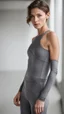 Placeholder: photography of a beautiful anorexic woman, grey satin triathlon top, brunette wavy pixie haircut, pronounced sternum, flat chest, grey satin cycling leggins