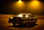 Placeholder: Coche Cadilac americano en mitad de la noche tan sólo iluminado por una farola y los potentes focos del coche, imagen al estilo del fotógrafo Hugo Alonso