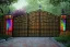 Placeholder: open iron gates made of colorful stained glass, covered in vines, trees, very large entry leading to a lush garden, see lot details in the garden, photo realistic 4k, nature, beautiful hand laid checkered pattern stone walkway path, trending on artstation, sharp focus, studio photo, intricate details, highly detailed, by greg rutkowski