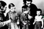 Placeholder: a photo of child-like Simone de Beauvoir and child-like Jean-Paul Sartre meeting child-like Che Guevara who is lighting a cigar for child-like Jean-Paul Sartre