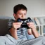 Placeholder: portrait of a boy playing video games in the room