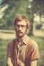 Placeholder: hippie young man with glasses of colours and poor and short short short and poor hair on the head with receding hairline. Farsightedness glasses with big eyes. Shirt beard in the head. Vintage look and feel like photo style-of the 70s