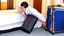 Placeholder: hotel clerk hiding suitcase from customer