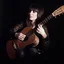 Placeholder: gypsy woman playing guitar. low lighting