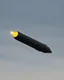 Placeholder: A black missile flying in the sky with a yellow dot