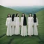 Placeholder: a group of women standing on top of a lush green hillside, inspired by Ren Hang, design milk, long black hair, whites, wanderers traveling from afar, trending on artisation, cloning spell, coat pleats, in twin peaks, submarine, by Helen Thomas Dranga, symetry, round-cropped, noire photo